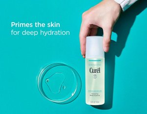 Hand holding Curél Hydrating Water Essence next to watery texture in glass dish
